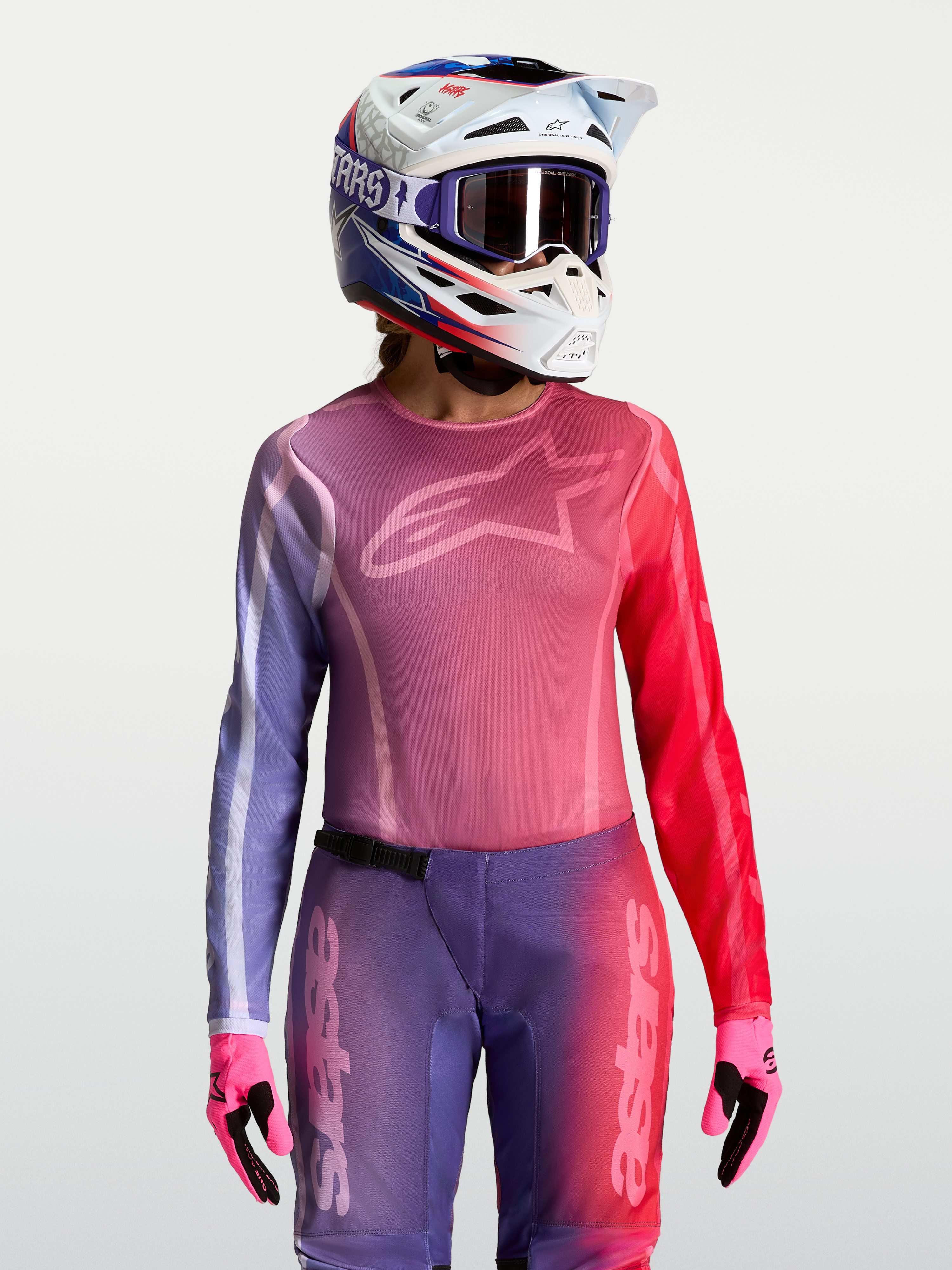 Alpinestars Stella Fluid Kepler, maglia motocross da donna, viola e rossa, vestibilità atletica e tessuto traspirante, indossata con casco e guanti coordinati per performance off-road