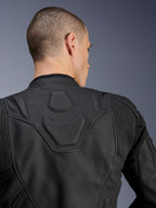 Giacca in pelle Alpinestars Dusk, nero, primo piano della parte superiore della schiena e delle spalle che mostra il logo DUSK goffrato su un pannello imbottito, inserti elastici in pelle a fisarmonica, costruzione in pregiata pelle bovina