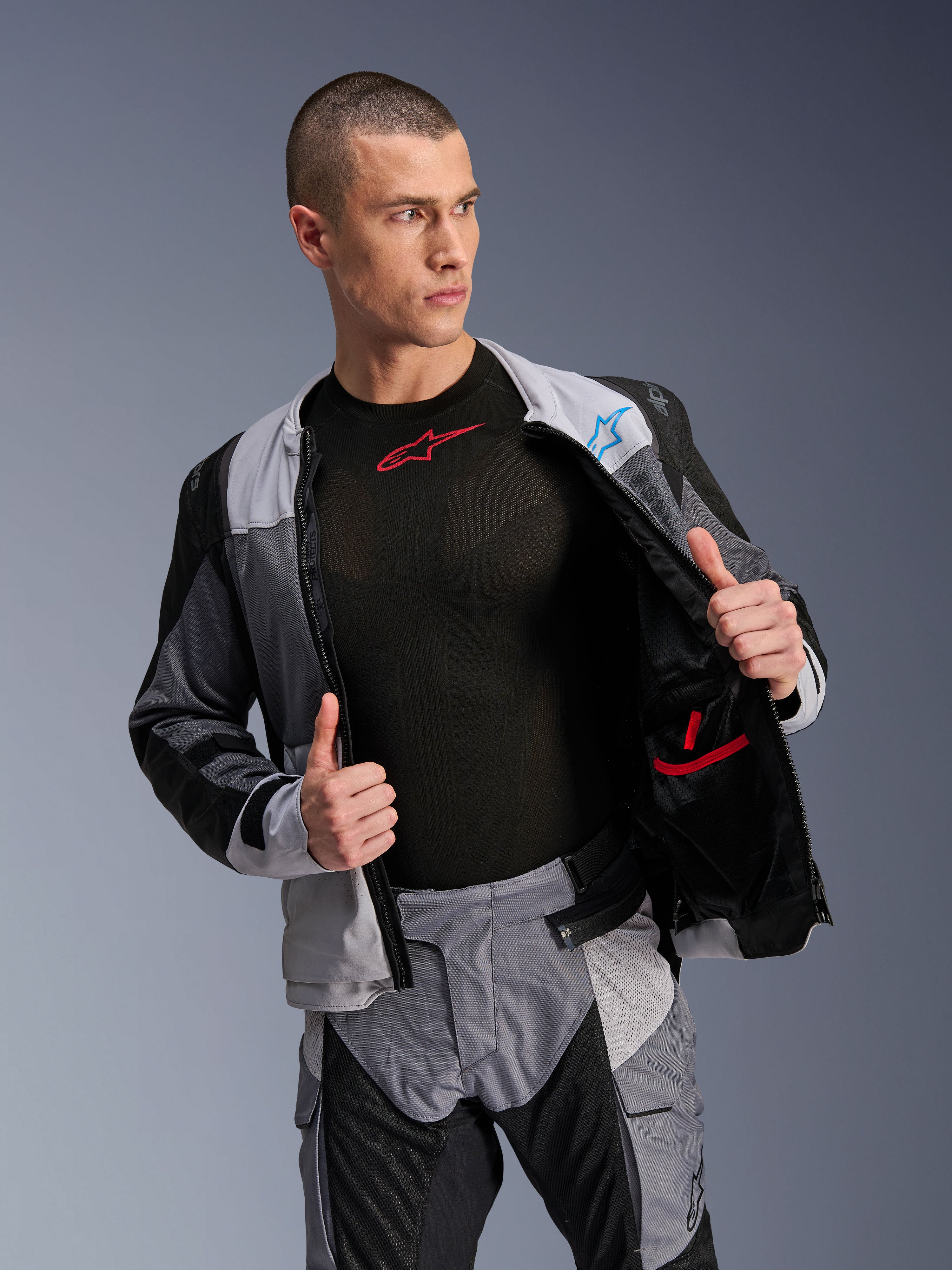 Giacca Alpinestars ST-2 Air, Ice Gray Dark Gray Black, giacca da touring per moto, indossata aperta per mostrare la fodera interna in rete e le tasche, abbinata a pantaloni coordinati e base layer nero