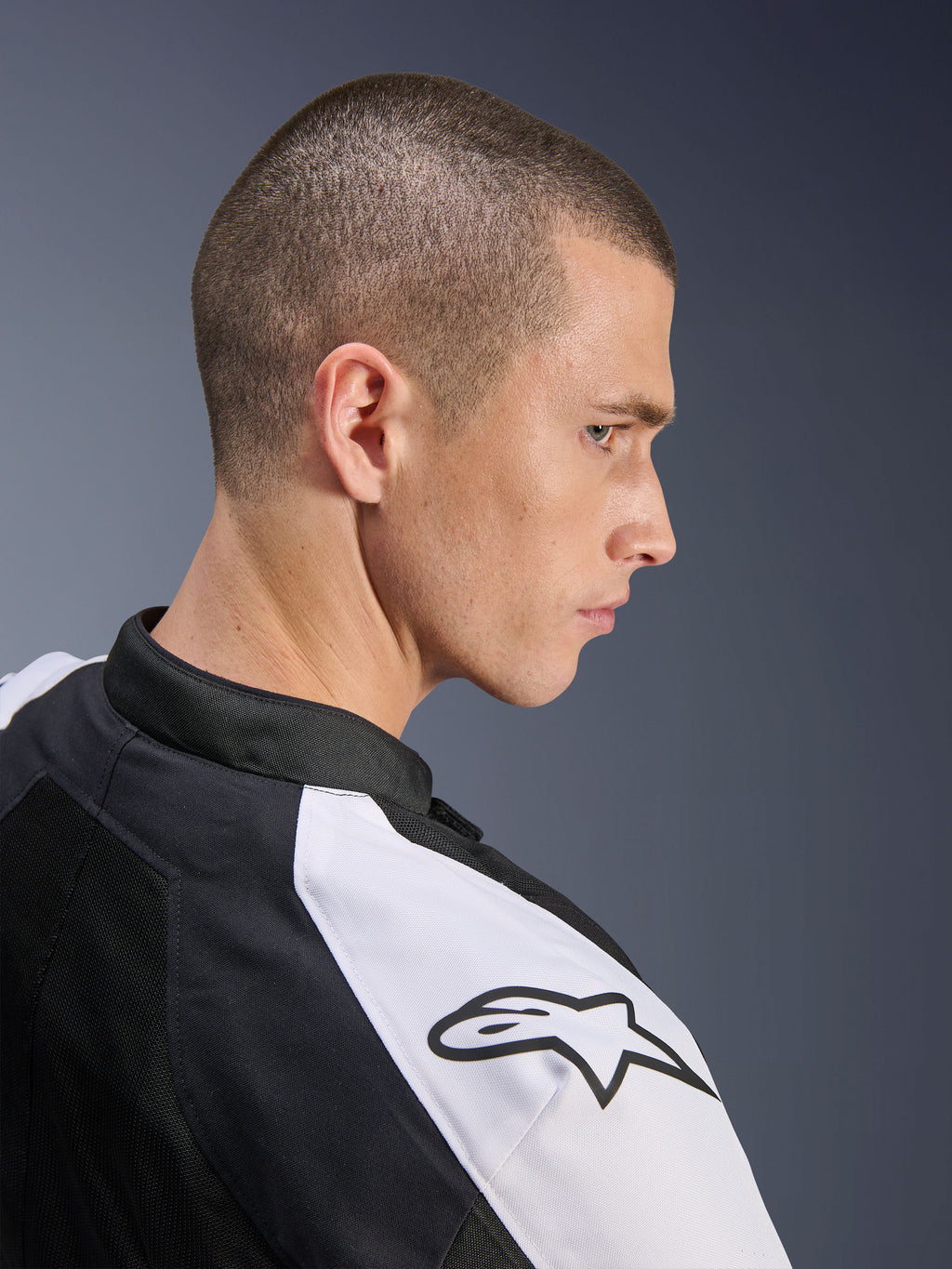 Giacca Alpinestars Viper Air V4, nero e bianco, profilo laterale di un modello che indossa la giacca, con pannello bianco sulla spalla e logo Alpinestars nero, costruzione in tech mesh per la ventilazione, abbigliamento sportivo da moto da strada