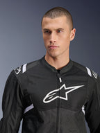 Giacca Alpinestars T-SPS Air V2, giacca da moto in tessuto, nero e bianco, con grande logo bianco sul petto e pannelli in mesh, vestibilità sportiva performante indossata da un modello