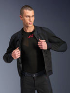 Giacca Alpinestars Troop-Air Pro, nera, giacca tecnica protettiva ventilata di alta qualità con struttura in mesh, indossata aperta su un base layer nero con logo rosso, abbinata a pantaloni da moto in mesh coordinati, stile di guida urban contemporary