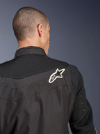 Giacca Alpinestars T-Dyno Air, giacca da moto in tessuto nero, vista ravvicinata posteriore che mette in risalto il giogo e le maniche in mesh 3D traspirante, con logo a stella bianco e nero sulla spalla destra.