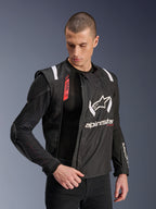 Giacca Alpinestars T-Stunt Air, giacca da moto nera e bianca, indossata da un modello, che mostra la costruzione modulare in mesh e le protezioni interne a vista su spalla e gomito, logo Alpinestars sul petto, predisposizione Tech-Air, taglio sportivo per guida su strada