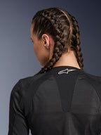 Giacca Alpinestars Stella Troop-Air da donna, nero, vista posteriore dettagliata della parte superiore della schiena e del collo, donna con capelli raccolti in trecce alla francese, con logo Astars bianco sul colletto e tessuto in mesh tecnico 2D leggero per la ventilazione