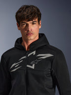 Alpinestars Chrome Superairflow Hoodie, felpa da moto nera, caratterizzata da una costruzione in mesh 3D con un grande logo grafico bianco sul petto, indossata da un modello, abbigliamento per guida sportiva urbana dal moderno design ventilato