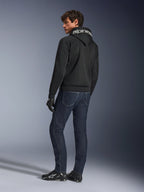 Alpinestars Chrome Superairflow Hoodie, nero, vista posteriore su modello, con marchio Alpinestars bianco sul cappuccio, indossata con jeans in denim scuro e guanti neri, design per abbigliamento moto urbano