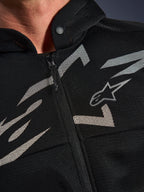 Alpinestars Chrome Superairflow Hoodie, felpa da moto, nera con grafiche bianche e grigie, primo piano del petto con costruzione in mesh tecnico 3D, cerniera anteriore e colletto con bottone a pressione, logo Alpinestars