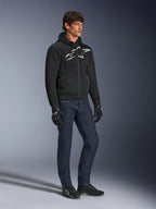 Felpa Alpinestars Chrome Superairflow, nera con logo bianco e grigio, costruzione in tessuto mesh 3D ventilato, indossata con jeans in denim blu scuro e guanti da moto neri, stile di guida urban sport.