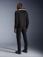 Alpinestars Chrome V2 Sport Hoodie, nero, vista posteriore con branding Alpinestars bianco sul cappuccio, indossata con pantaloni neri e scarpe da moto, abbigliamento da moto urban casual dalla silhouette atletica