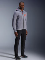 Alpinestars Chrome V2 Sport Hoodie, Grigio Melange e Rosso Fluo, indossata da un modello con pantaloni neri e scarpe sportive scure, caratterizzata da un logo a stella arancione brillante sul petto e sul cappuccio, abbigliamento casual per guida urbana