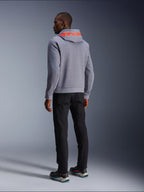 Alpinestars Chrome V2 Sport Hoodie in grigio melange, vista posteriore con grande logo Alpinestars rosso fluorescente sul cappuccio, indossata con pantaloni neri e scarpe da moto scure, abbigliamento moto casual urbano