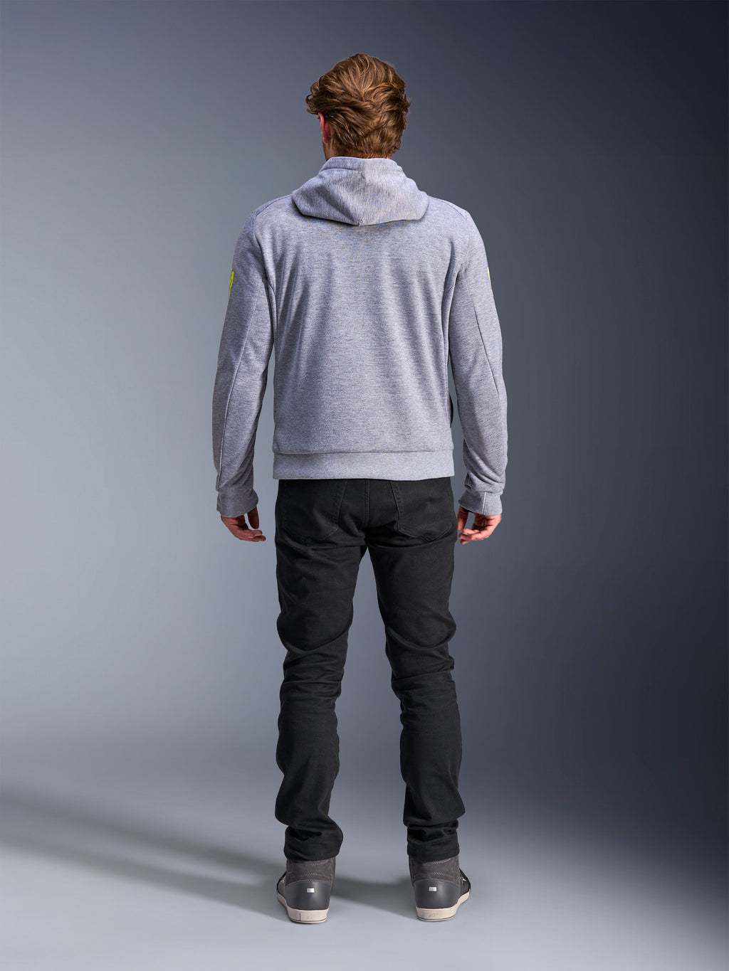 Alpinestars Chrome V2 Sport Hoodie, grigio melange giallo fluo, vista posteriore di abbigliamento da moto urbano, felpa con cappuccio in pile tecnico indossata con pantaloni neri, con accenti giallo fluo sulle maniche