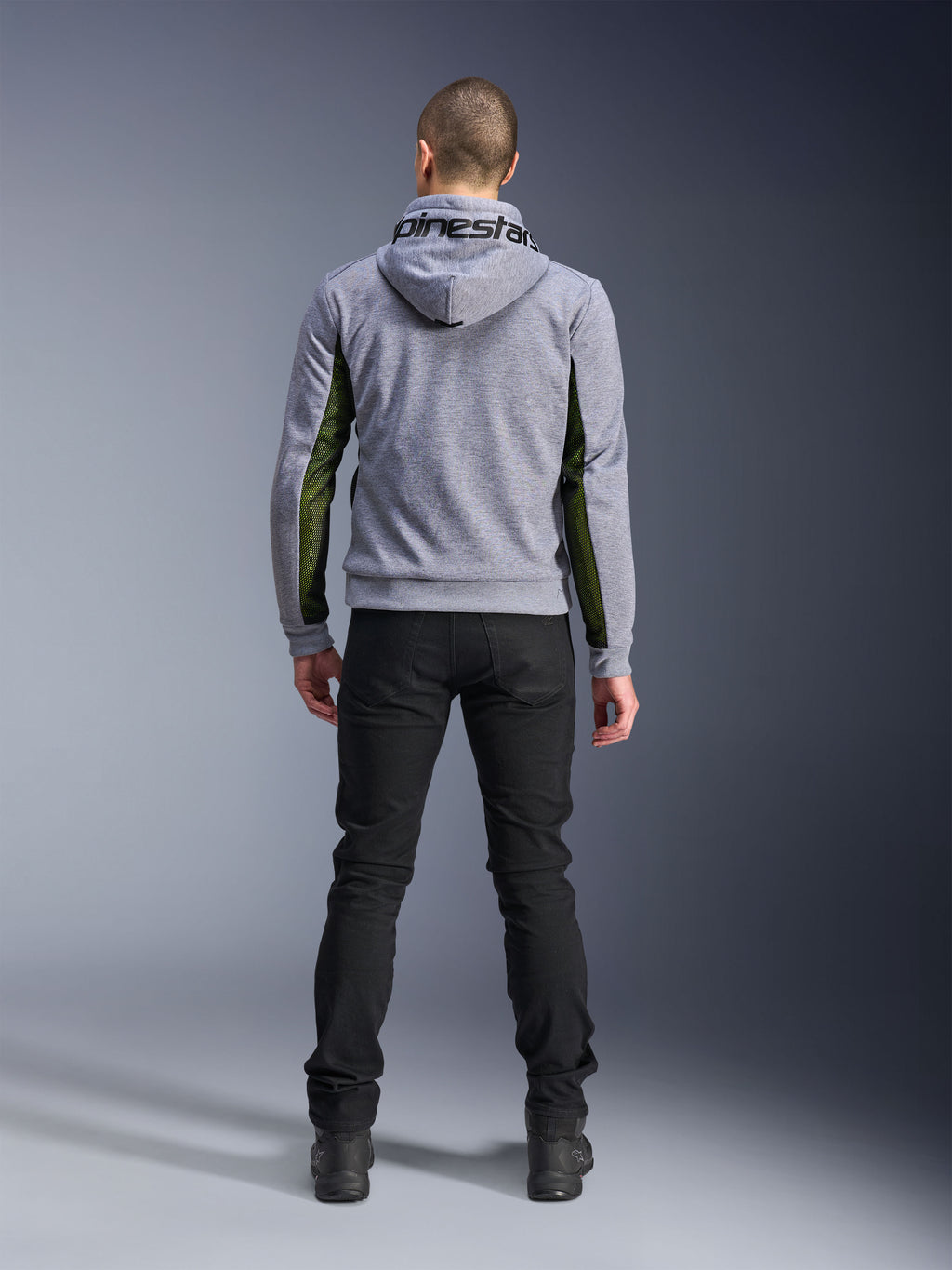 Alpinestars Chrome Air Sport Hoodie, Grigio Heather Nero, vista posteriore della felpa da moto con pannelli in mesh verde ad alto flusso sui lati e sulle maniche, costruzione in pile tecnico con marchio Alpinestars sul cappuccio, indossata con pantaloni neri