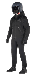 Felpa con cappuccio Alpinestars Moflow Air Tech, felpa da moto urban, Nero Nero, indossata da un pilota con casco nero opaco, guanti neri e pantaloni da guida, caratterizzata da una costruzione interamente in mesh per la circolazione dell'aria, tasche con zip e loghi discreti sul petto, design casual ed elegante per la guida su strada con clima caldo.