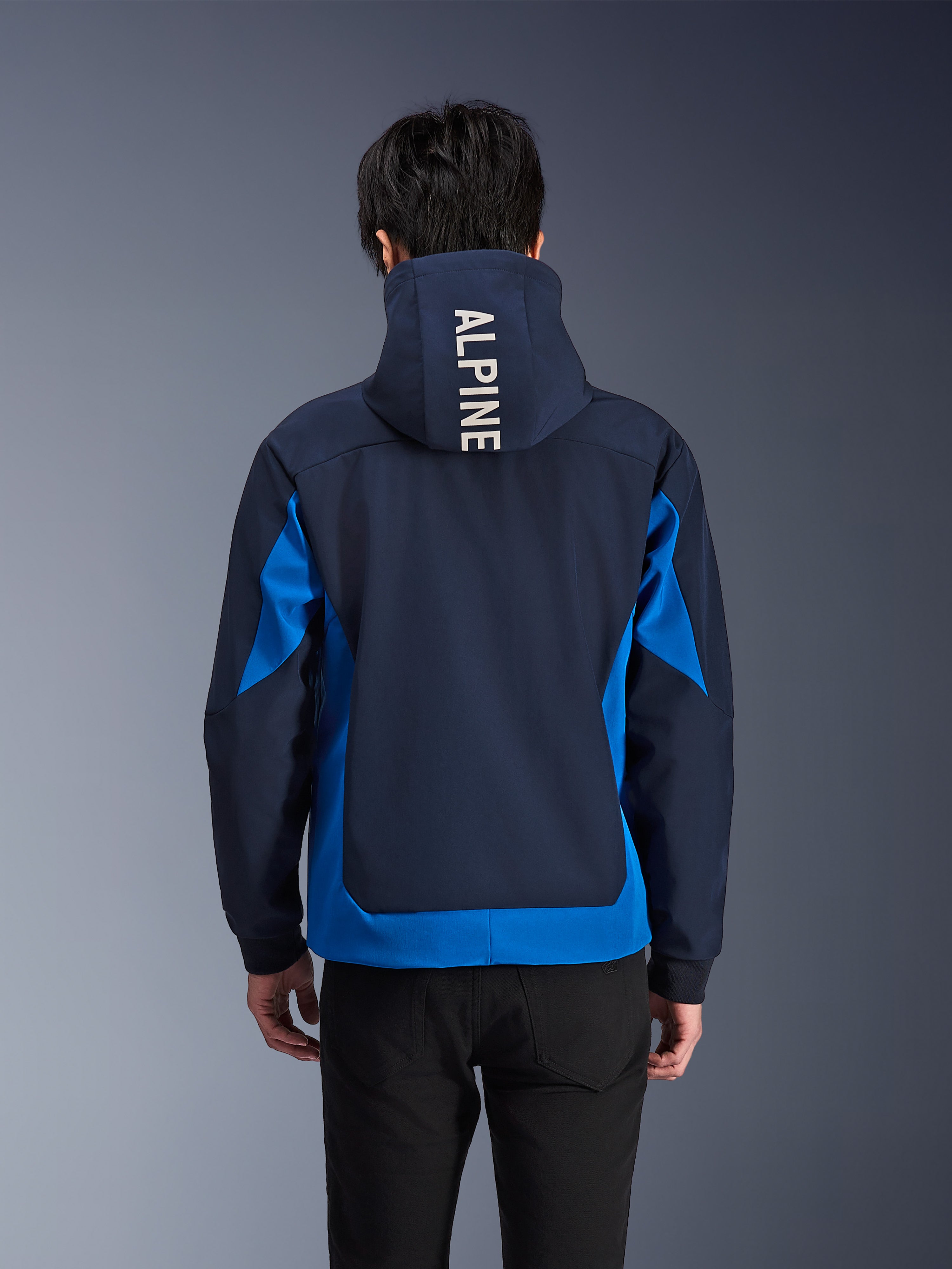Alpinestars Radium Tech Hoodie, giacca da moto blu notte e blu reale, vista posteriore che mostra il marchio 'ALPINE' bianco sul cappuccio, abbigliamento urban performance con vestibilità atletica e pannelli di colore a contrasto
