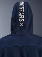 Alpinestars Radium Tech Hoodie in Night Navy Royal Blue, primo piano del cappuccio posteriore con branding Alpinestars verticale bianco e sistema di fissaggio ad asola, abbigliamento tecnico da moto urbano.