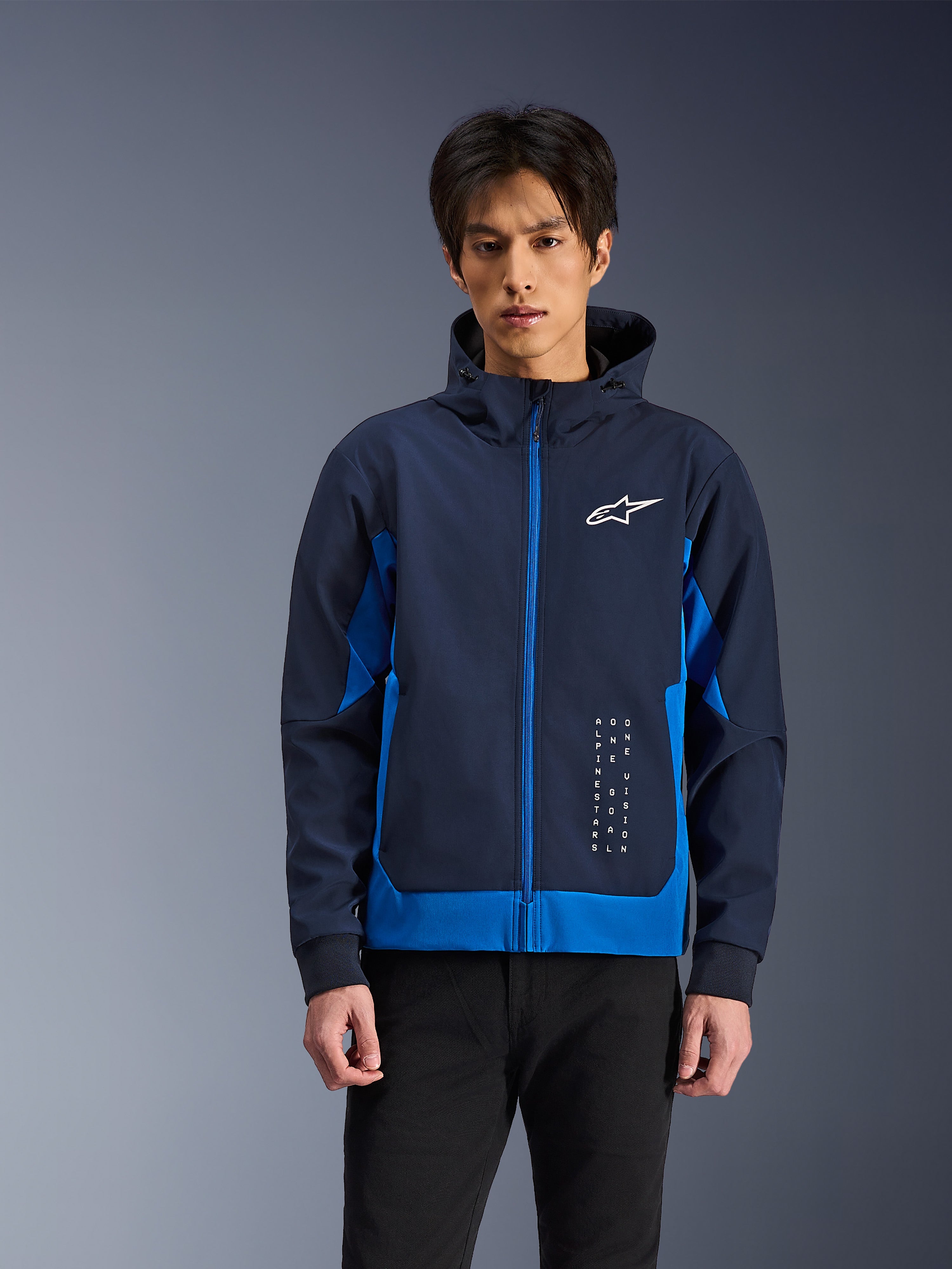 Alpinestars Radium Tech Hoodie, giacca da moto urbana, Night Navy e Royal Blue, con zip frontale, logo bianco sul petto e branding verticale, costruzione in guscio tecnico con vestibilità atletica