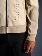 Alpinestars Radium Tech Hoodie in Mastic Aluminum, vista ravvicinata di petto e manica, branding con testo verticale nero 'Alpinestars One Goal One Vision', polsino elasticizzato a coste e dettaglio della zip, giacca da moto urbana in tessuto