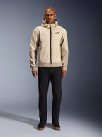 Alpinestars Radium Tech Hoodie in Mastic Aluminum, felpa da moto urbana indossata da un modello con pantaloni neri e stivali neri, caratterizzata da una cerniera nera a tutta lunghezza, un piccolo logo sul petto e una vestibilità atletica per la guida in città.