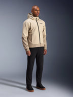 Alpinestars Radium Tech Hoodie, giacca da moto urbana, beige chiaro Mastic Aluminum, indossata con pantaloni neri e sneaker alte nere, dotata di guscio tecnico antivento, cerniera frontale e cappuccio rimovibile, design streetwear moderno per la guida urbana
