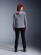 Alpinestars Stella Chrome V2 Sport Hoodie, felpa da moto da donna, grigio mélange e rosa fluo, vista posteriore con logo Alpinestars rosa sul cappuccio, indossata con pantaloni da guida e stivali neri, abbigliamento moto casual da donna