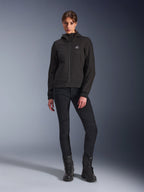 Alpinestars Stella Radium Tech Hoodie in nero, guscio tecnico da moto urban per donna, indossata con pantaloni neri slim-fit e stivali neri, dotata di piccolo logo sul petto e cappuccio, costruzione leggera e antivento per la guida urbana