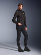 Alpinestars Stella Radium Tech Hoodie, felpa da moto urbana nera da donna, indossata con pantaloni da guida neri e stivali in stile tattico, vestibilità atletica slim, guscio tecnico a 3 strati antivento, design minimalista con piccolo logo sul petto, scatto in studio a figura intera