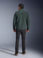 Alpinestars Bryon Water Resistant Overshirt in Dark Emerald, vista posteriore su modello, abbinata a pantaloni da moto grigio scuro e scarpe da guida nere, design classico ispirato all'abbigliamento da lavoro con retro leggermente più lungo per maggiore copertura durante la guida