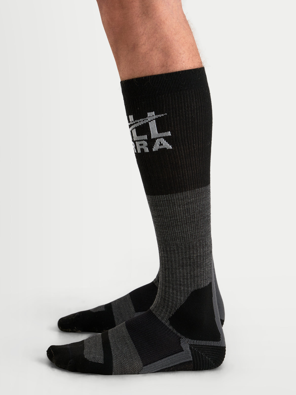 Alpinestars AT-8 Merino Calzini, calzini da moto adventure lunghi, grigio scuro e nero, misto lana merino termica con polsino superiore a costine e rinforzo su tallone e punta, indossati su un modello