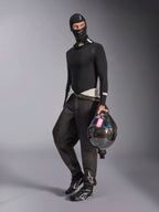 Passamontagna Alpinestars ZX Evo V3, nero, indossato da un pilota con abbigliamento intimo da corsa completo, logo bianco sulla fronte, con casco in fibra di carbonio e visiera iridescente, abbigliamento professionale ignifugo per motorsport.