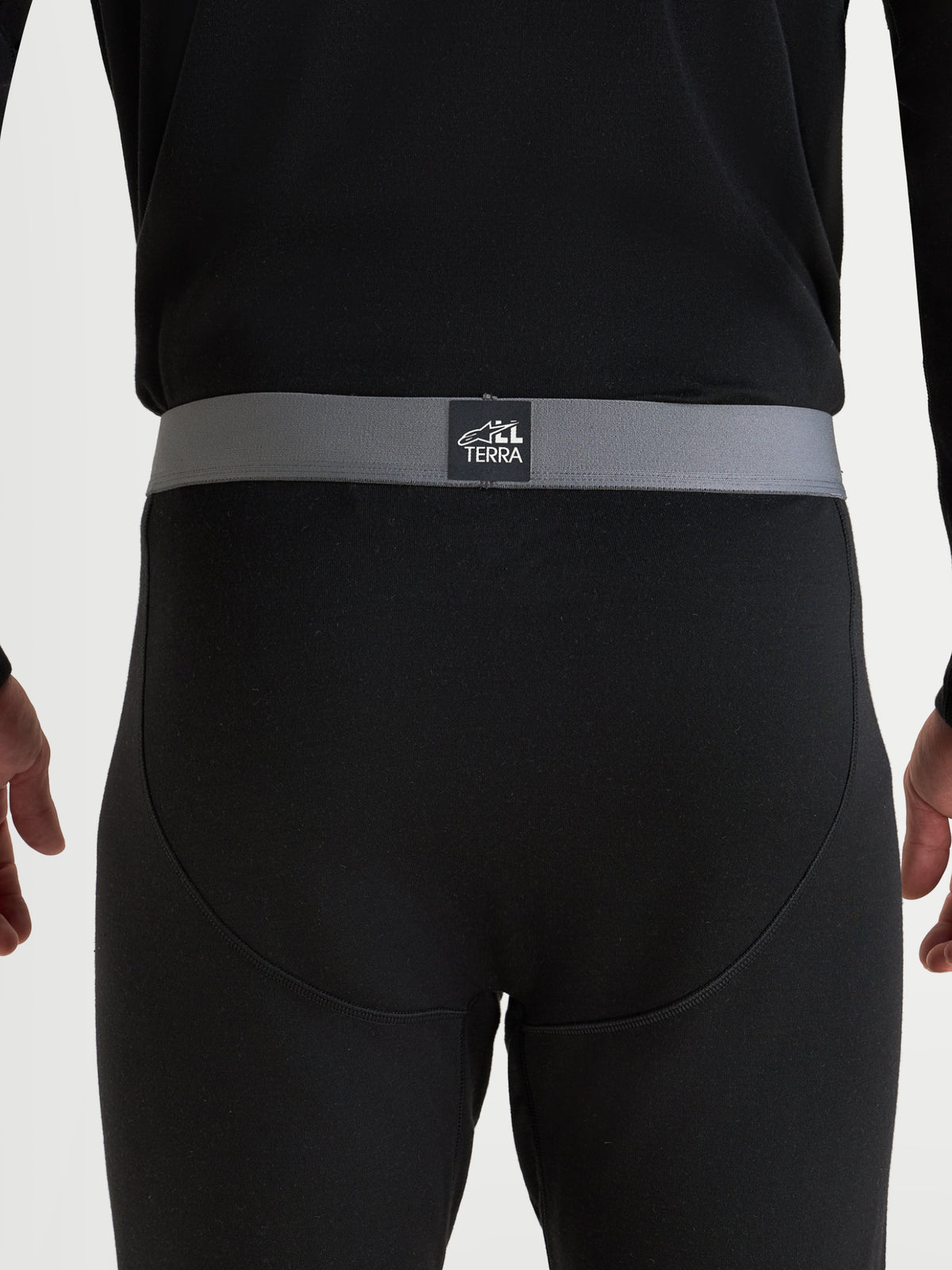 Alpinestars AT-8 Merino Bottom Intimo Tecnico, intimo tecnico da moto adventure da uomo, nero, primo piano della vista posteriore che mostra la cintura elastica grigia con marchio All Terra e costruzione senza cuciture