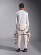 Alpinestars ZX Evo V3 Top - Long Sleeve, sottotuta bianco per corse automobilistiche, vista posteriore di una persona che indossa la maglia ignifuga con una tuta da gara abbassata in vita, abbinata a stivali da corsa neri, intimo tecnico professionale per motorsport