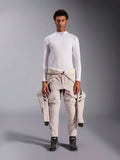 Alpinestars ZX Evo V3 Top, a maniche lunghe, bianco, base layer per corse automobilistiche indossato con una tuta da gara chiara legata in vita e stivali da corsa neri, con collo a lupetto con logo e branding sulle spalle, intimo professionale ignifugo per motorsport