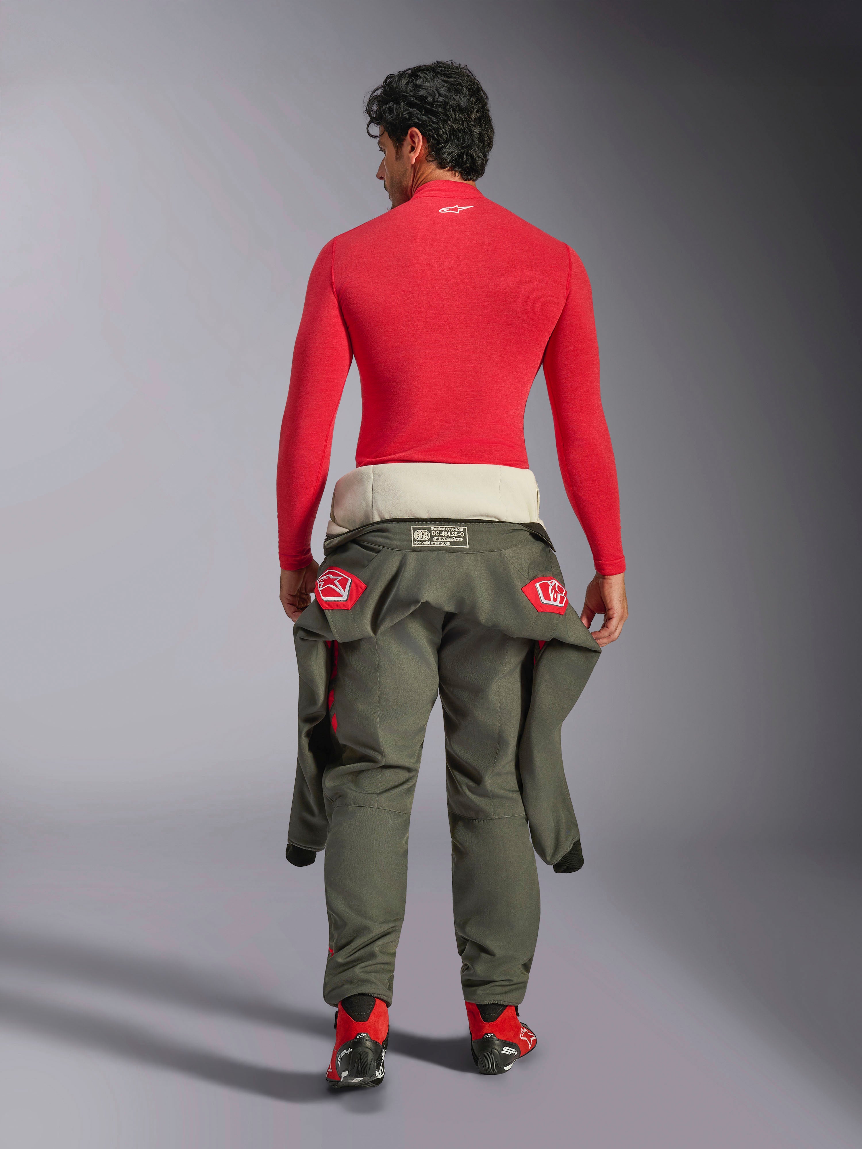 Alpinestars ZX Evo V3 Top - Manica Lunga, base layer per automobilismo rosso, vista posteriore di un modello maschile che indossa il top ignifugo con pantaloni da corsa verde oliva legati in vita e stivali rossi, attrezzatura professionale per motorsport