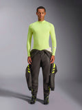 Alpinestars ZX Evo V3 Top - Maniche Lunghe, Giallo Fluo, indossato da un modello con pantaloni da corsa scuri e stivali, con collo a lupetto e vestibilità atletica, strato di base ignifugo per automobilismo professionale