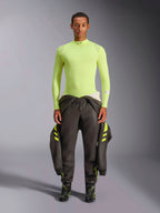 Alpinestars ZX Evo V3 Top - Maniche Lunghe, Giallo Fluo, indossato da un modello con pantaloni da corsa scuri e stivali, con collo a lupetto e vestibilità atletica, strato di base ignifugo per automobilismo professionale