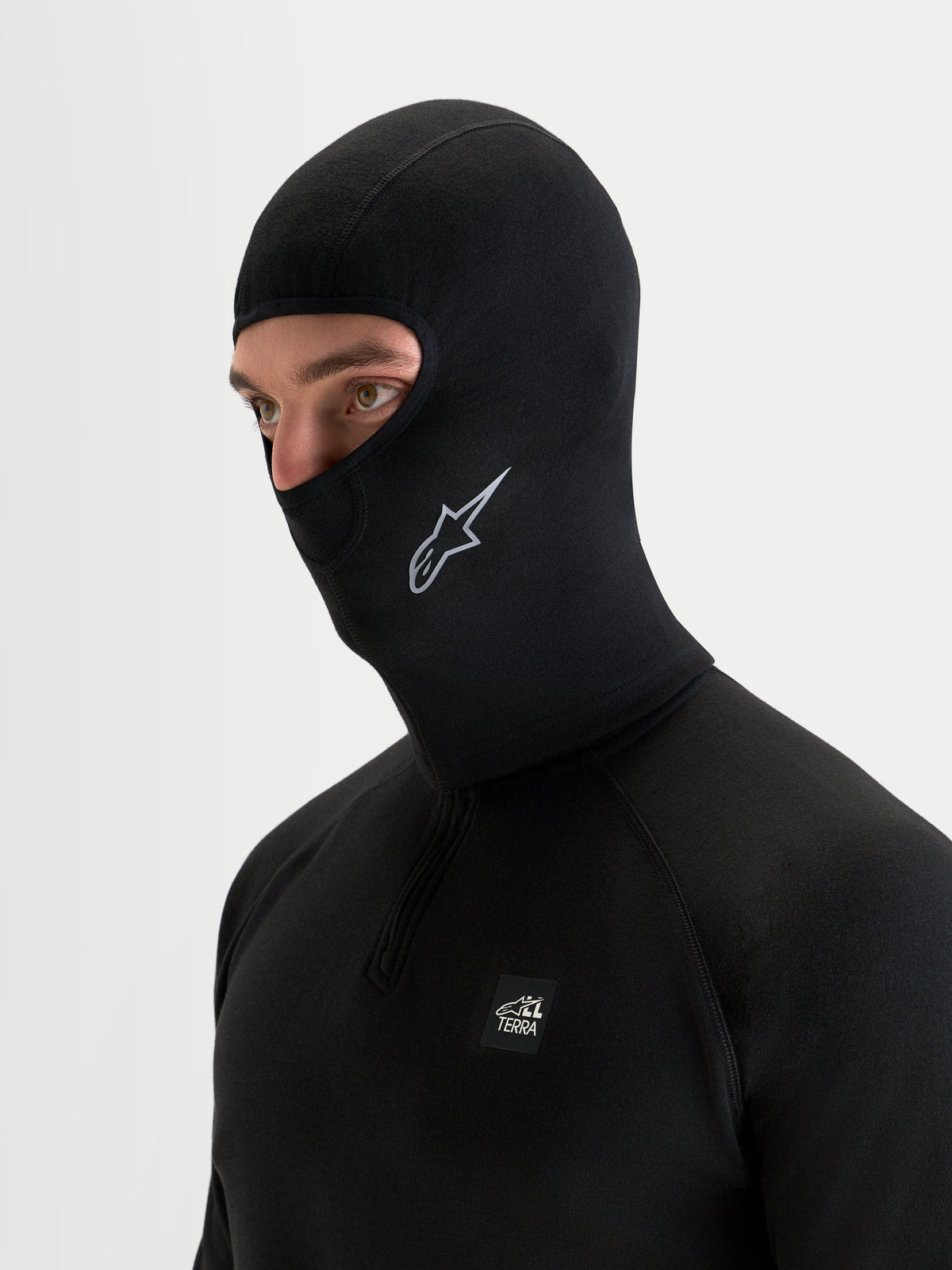 Alpinestars At 8 Merino Balaclava, passamontagna da moto tecnico in tessuto merino nero indossato da un modello, con struttura termica e copertura estesa sul collo