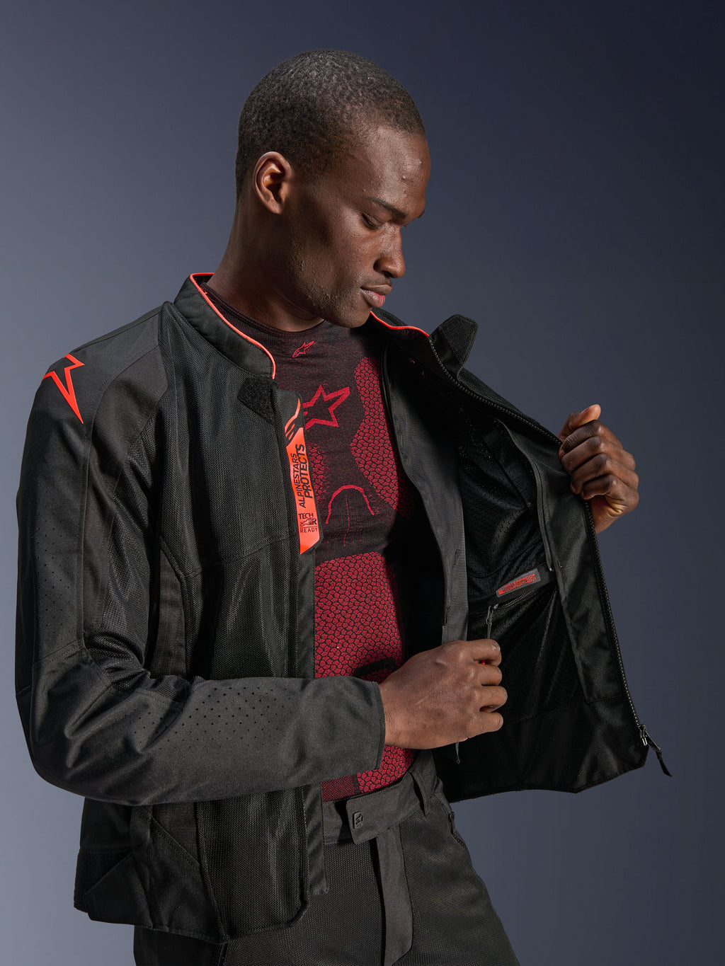 Giacca Alpinestars Viper Air V4, Nero Rosso Fluo, giacca da moto con pannelli in rete tecnica, modello che mostra lo scomparto interno impermeabile e la fodera interna, con accenti rosso fluo e logo Tech-Air Ready.