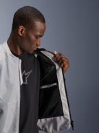 Modello che indossa la giacca Alpinestars C-1 Air in argento, aperta sul davanti per mostrare la fodera interna in mesh tecnico nero e la tasca interna impermeabile con zip.