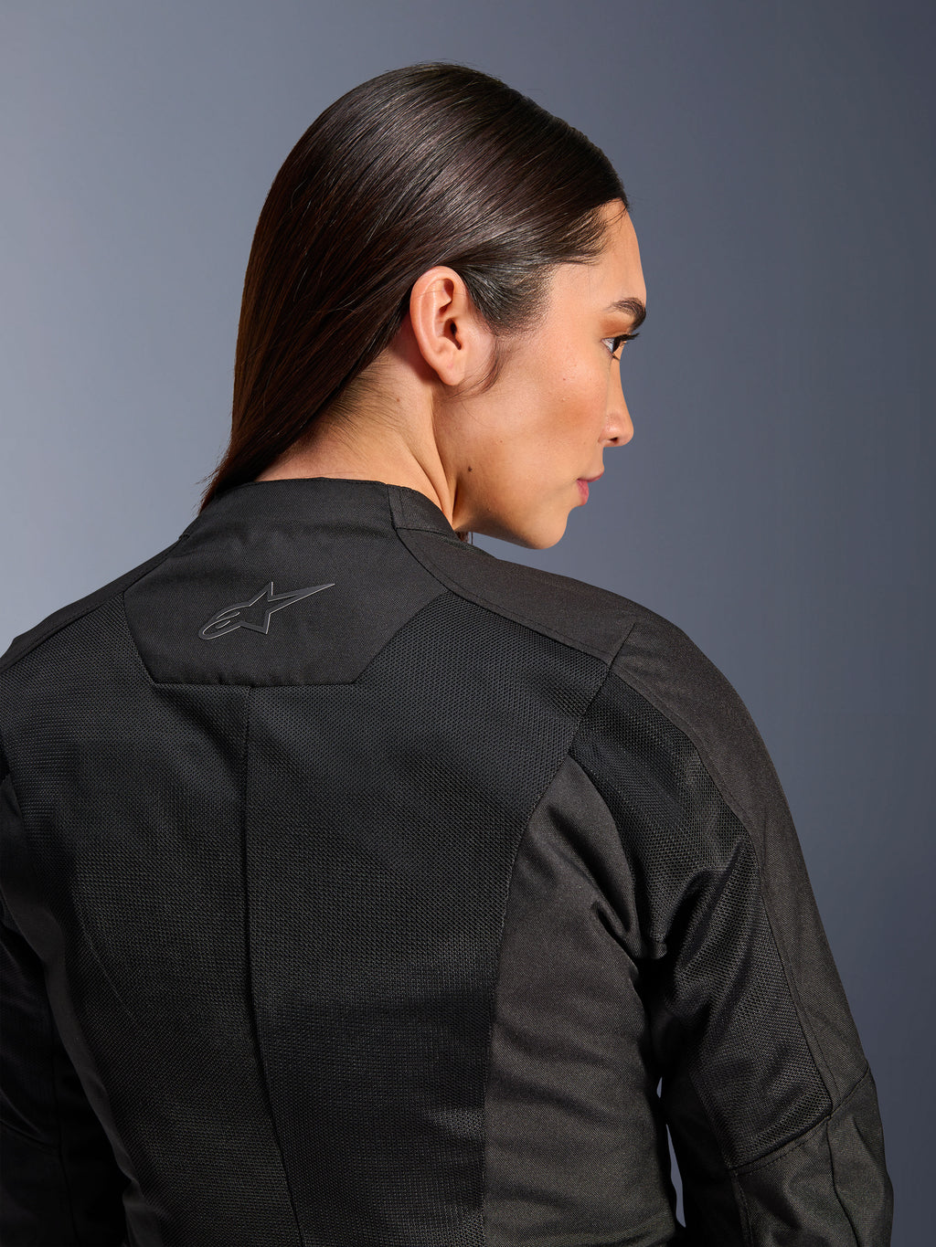 Giacca Alpinestars Stella C-1 Air da donna, giacca da moto in tessuto, nero, vista posteriore ravvicinata che mostra i pannelli di ventilazione in mesh tecnico e un logo a stella riflettente sulla parte superiore della schiena, abbigliamento moderno per la guida urbana