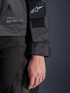 Alpinestars Molly Air Jacket, dettaglio ravvicinato del tessuto ripstop nero, logo Astar bianco sulla tasca della manica con toppa in velcro, polsino regolabile e testo del marchio stampato sul lato, abbigliamento moto urban da donna