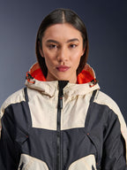 Alpinestars Molly Air Jacket, giacca da moto da donna in tessuto, Black Almond, vista frontale ravvicinata di una modella che indossa la giacca con design a pannelli crema e nero, cappuccio con fodera in rete arancione vivace e dettagli traforati al laser sul petto