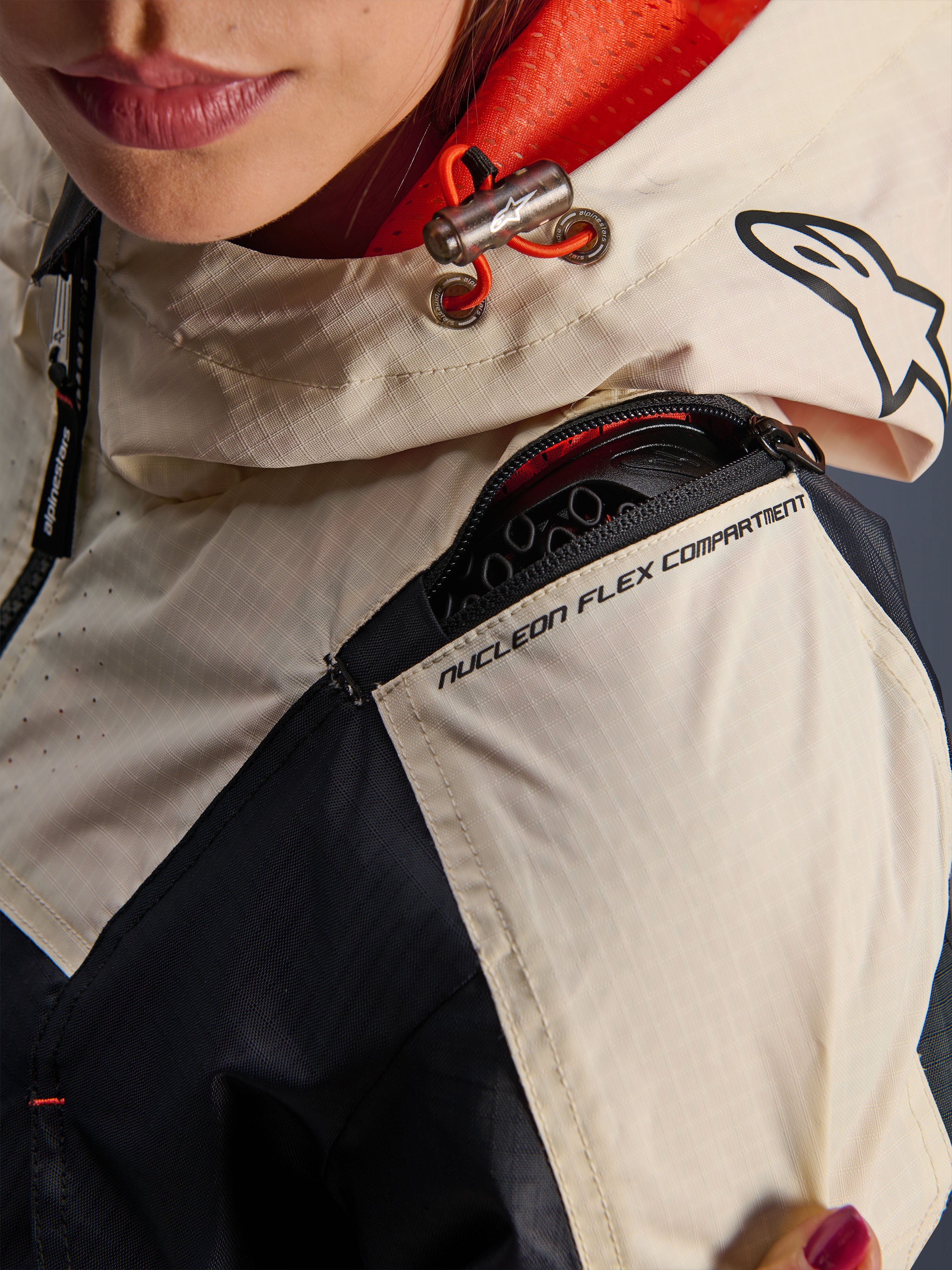 Alpinestars Molly Air Jacket, giacca da moto da donna, Black Almond, vista ravvicinata della spalla che mostra la cerniera del compartimento Nucleon Flex, tessuto ripstop e fodera in rete arancione all'interno del cappuccio