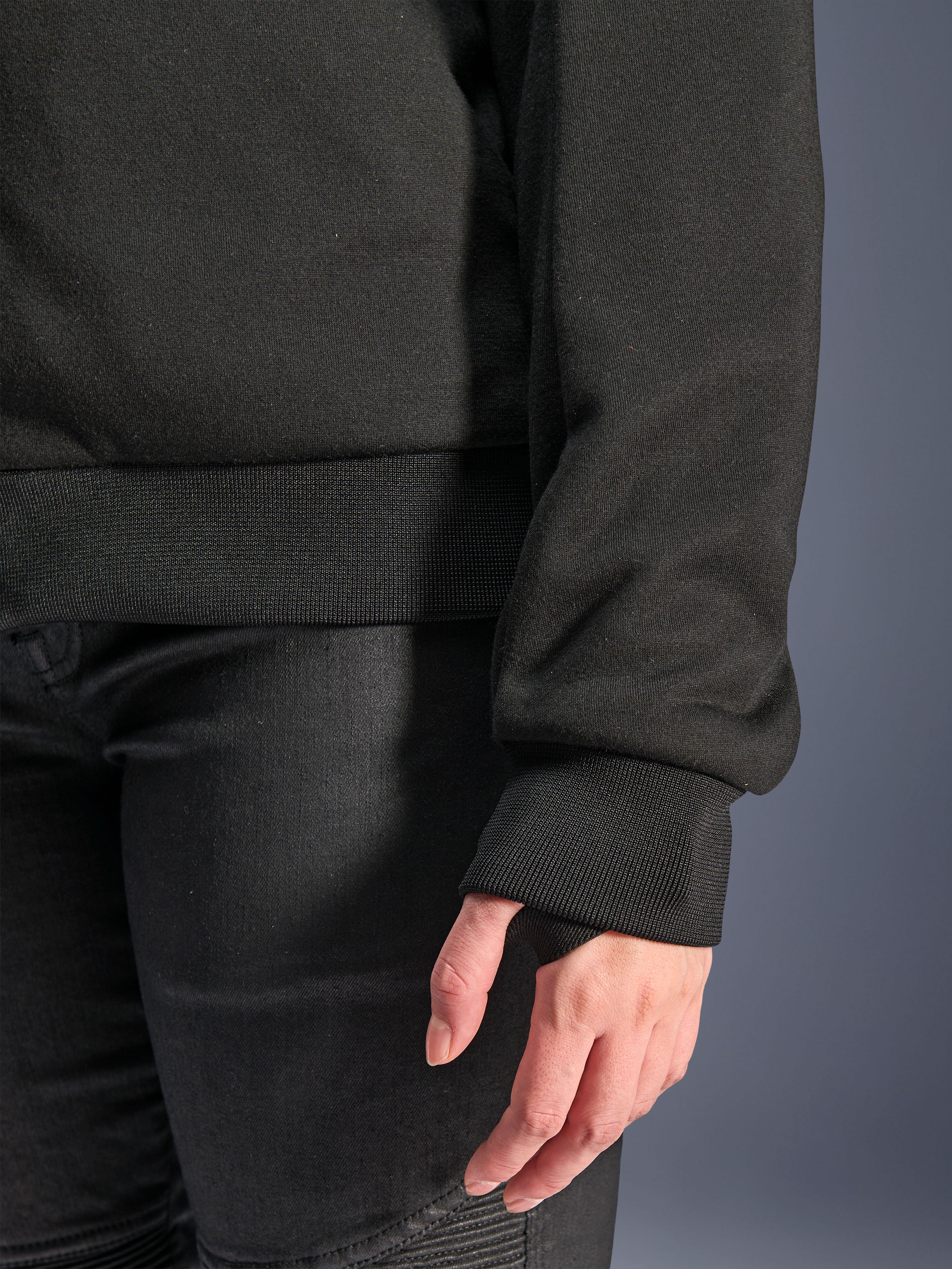Alpinestars Stella Chrome V2 Sport Hoodie, nero, primo piano del polsino a coste con foro per il pollice e orlo in vita a coste, materiale in pile tecnico per la guida urbana in moto