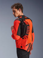 Alpinestars MM93 Waist Bag, marsupio nero con dettagli rosso fluo e rosso brillante, indossato da un modello sulla schiena sopra una giacca da moto rossa e nera, con loghi MM93 e grafiche Marc Marquez