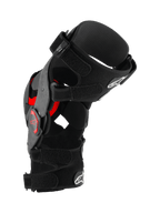 Alpinestars Supertech RK-10 Plasma Knee Brace, ginocchiera da motocross, nero e rosso, vista di profilo laterale che mostra il telaio in fibra di carbonio forgiata, cinghie regolabili e inserti Nucleon PLASMA rossi, attrezzatura protettiva per gare fuoristrada
