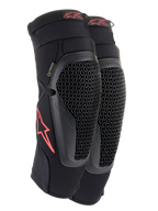 Ginocchiere Alpinestars Bionic Flex, nero e rosso, paio di ginocchiere da motocross con protezioni in tecnologia Nucleon Flex traforata, loghi Astars rossi e cinghie elasticizzate su una guaina in rete nera traspirante.