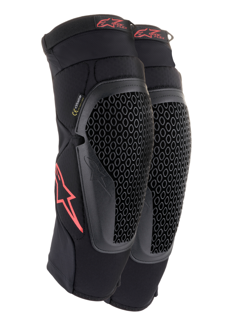 Ginocchiere Alpinestars Bionic Flex, nero e rosso, paio di ginocchiere da motocross con protezioni in tecnologia Nucleon Flex traforata, loghi Astars rossi e cinghie elasticizzate su una guaina in rete nera traspirante.
