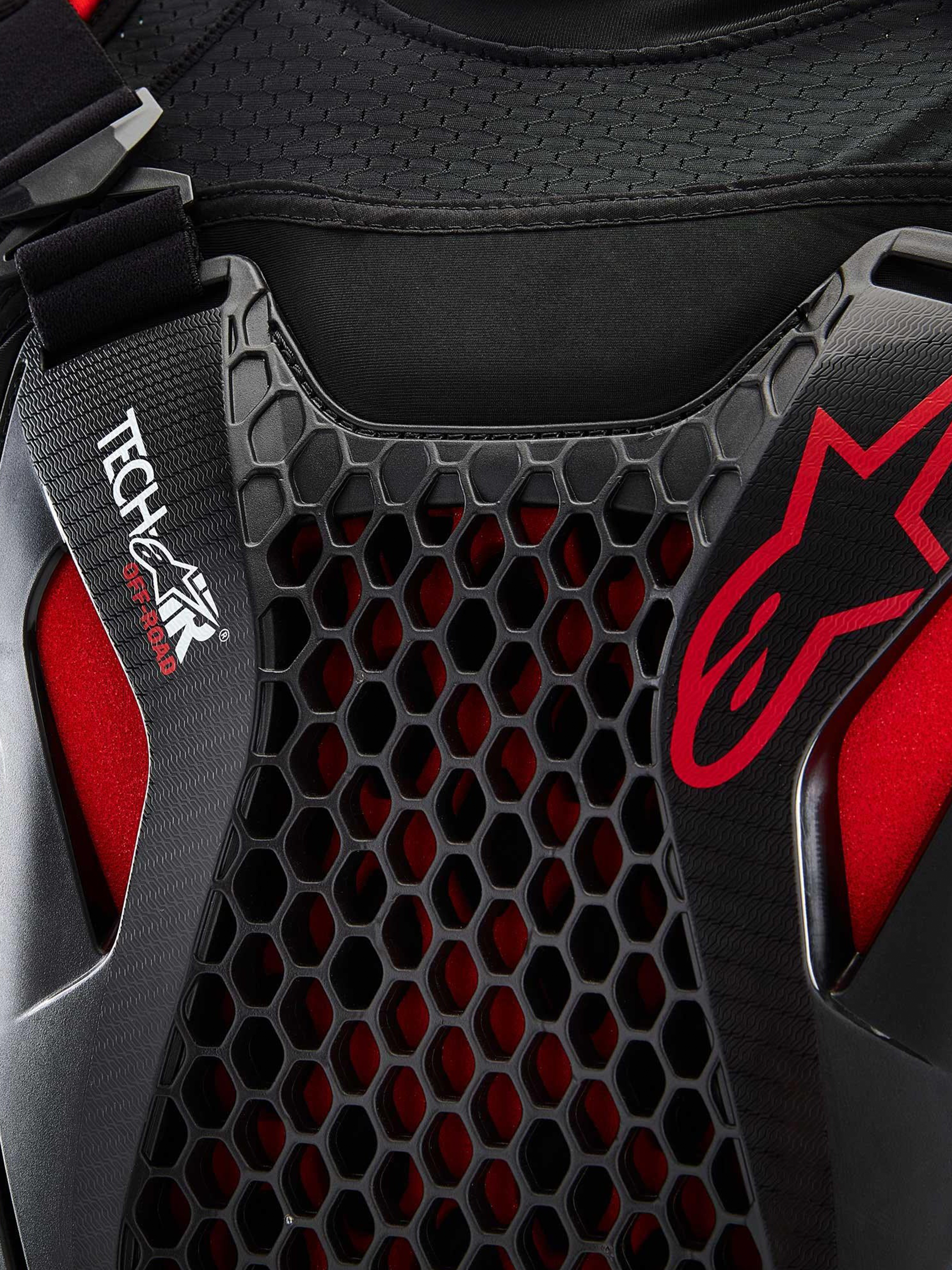 Alpinestars Airbag Tech-Air® Off-Road, sistema airbag off-road, dettaglio in primo piano nero e rosso con protezione torace Nucleon CELL a nido d'ape, marchio Tech-Air e tessuto a rete elasticizzato traspirante
